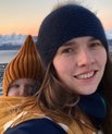 Photo shows Mette Mørup Schlütter in an arctic landscape, carrying a baby on her back