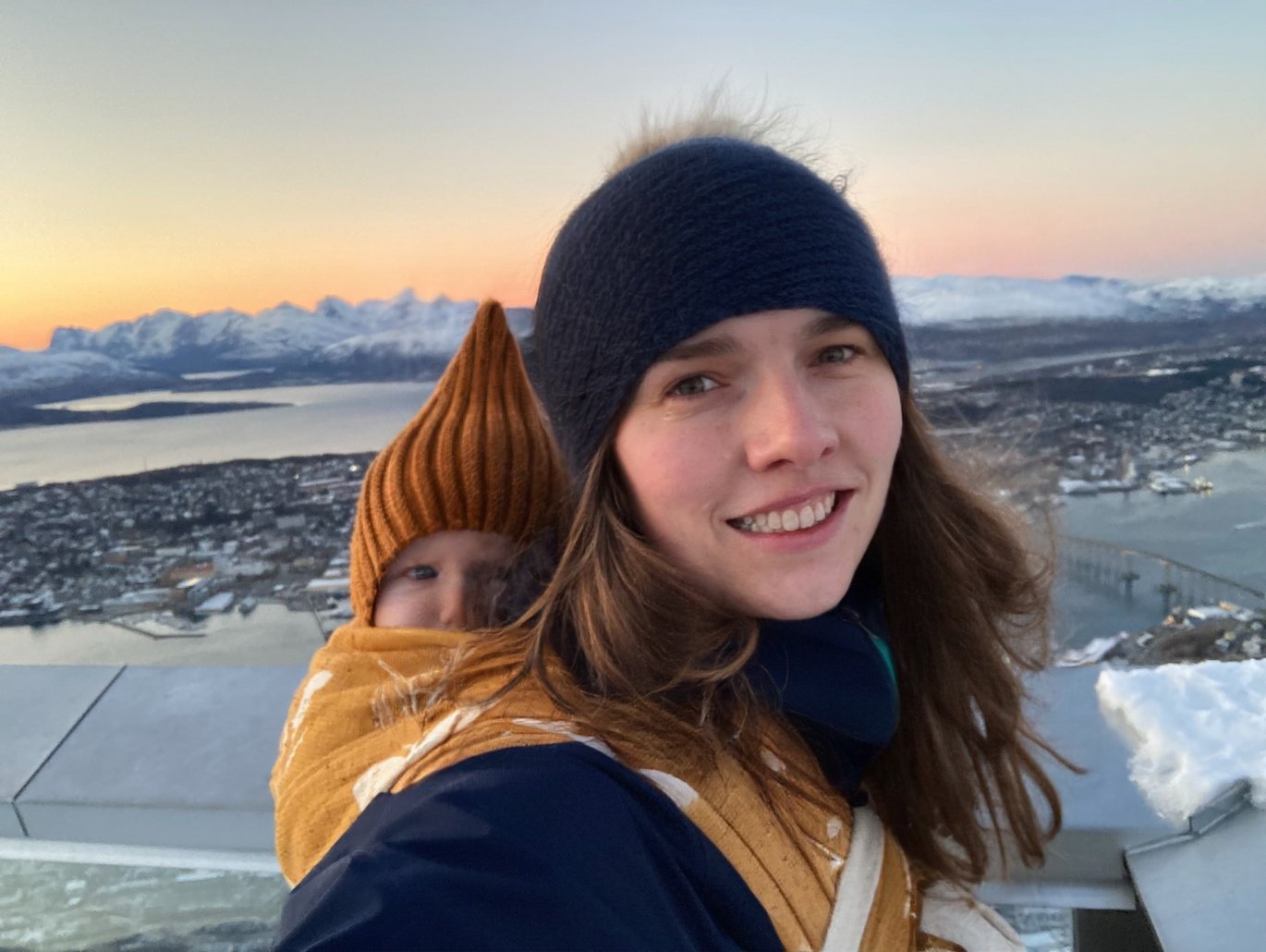 Photo shows Mette Mørup Schlütter in an arctic landscape, carrying a baby on her back